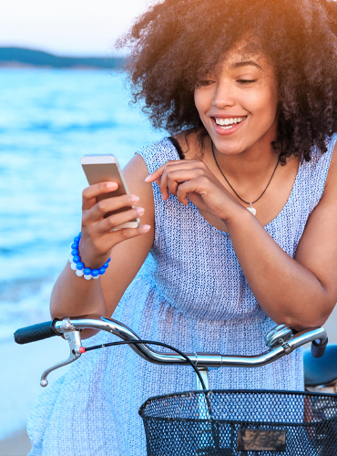 Woman on bike looking at cell phone