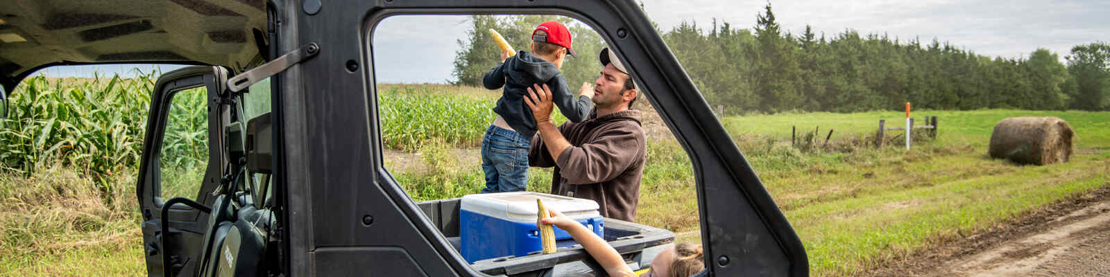 Father and son by a corn field