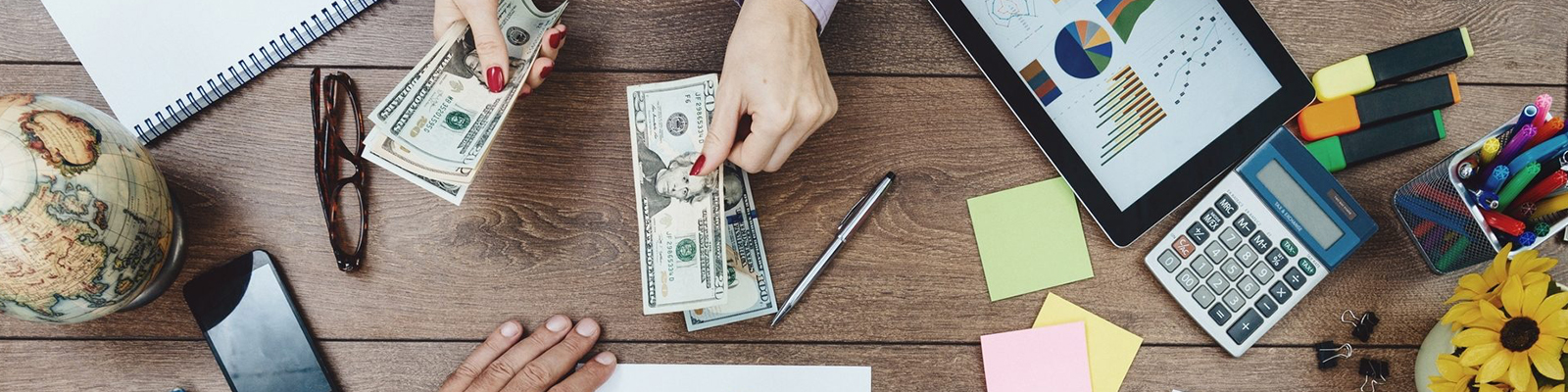 Money, tablet and calculator on table during meeting