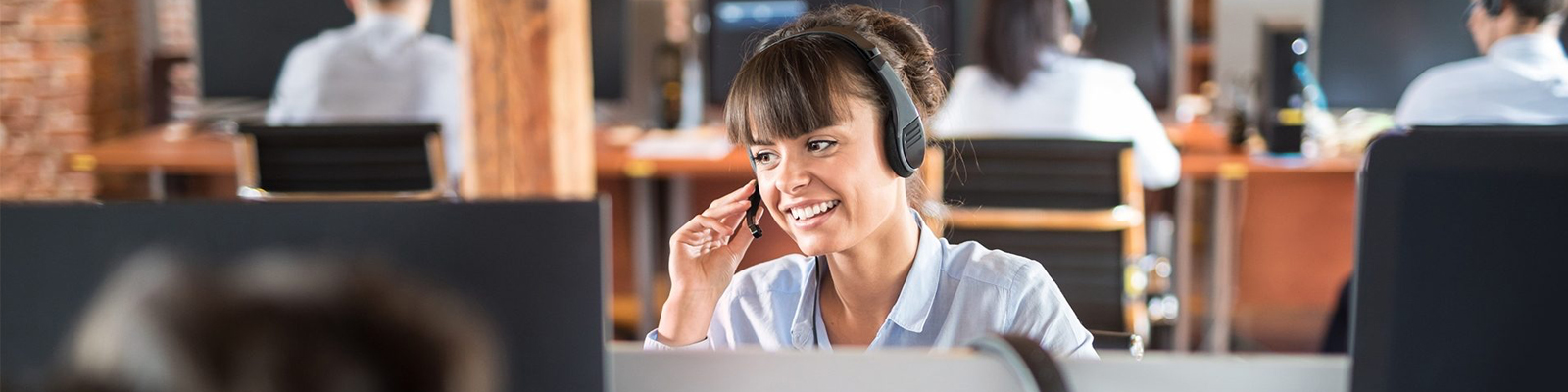 Woman with talking on a headset in call center.