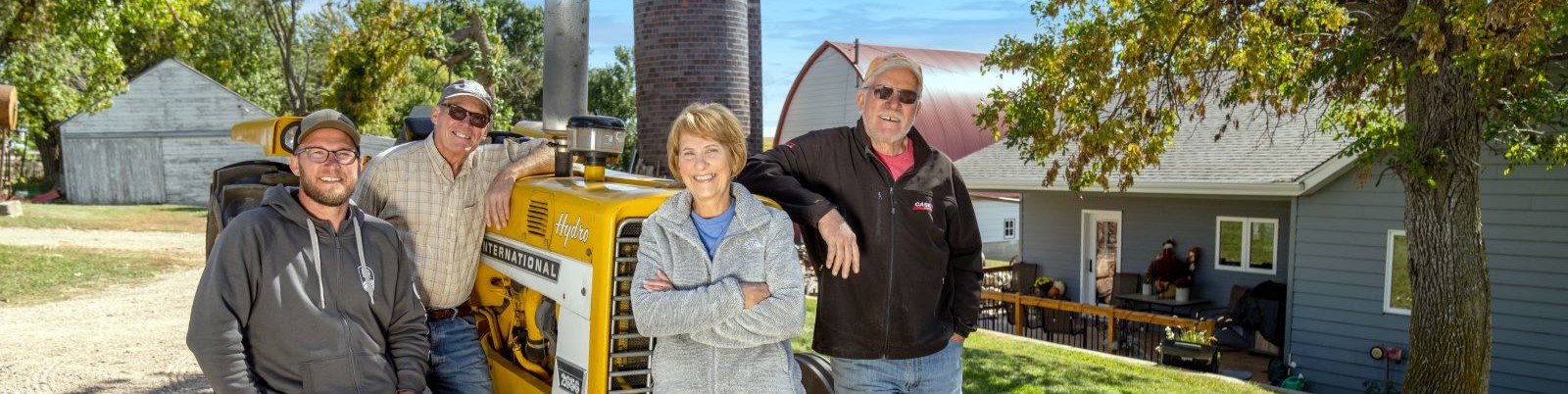Multi-generational Farm family next to a tractor. 