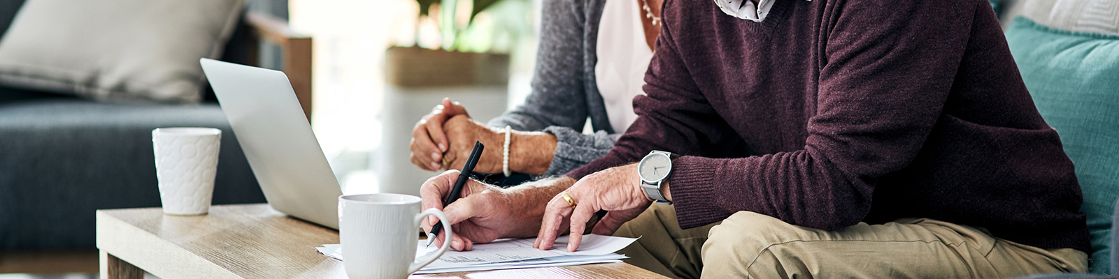 Couple sitting in living room going through paperwork