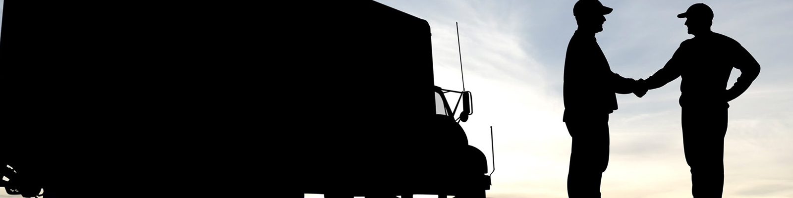 Shadow of two people shaking hands next to a truck