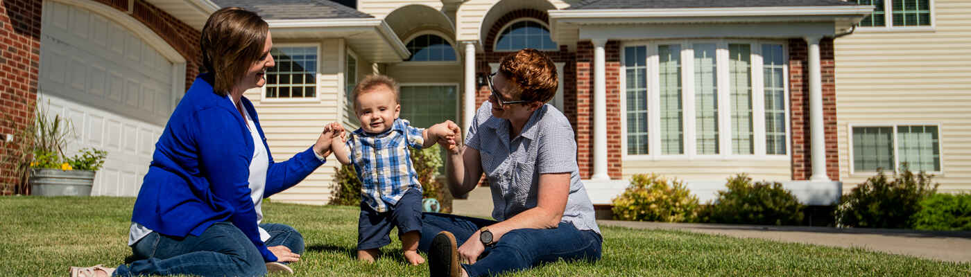 Family with baby in front of home