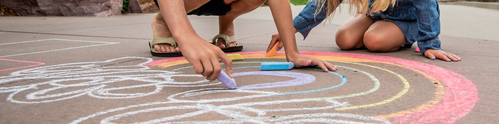 Kids drawing with sidewalk chalk