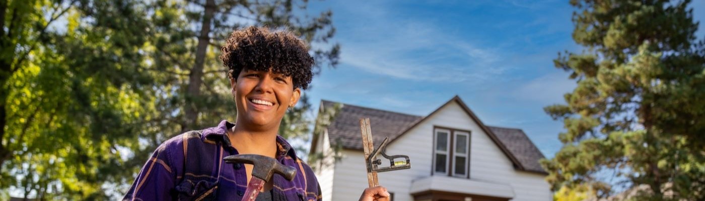Women with tools in front of house