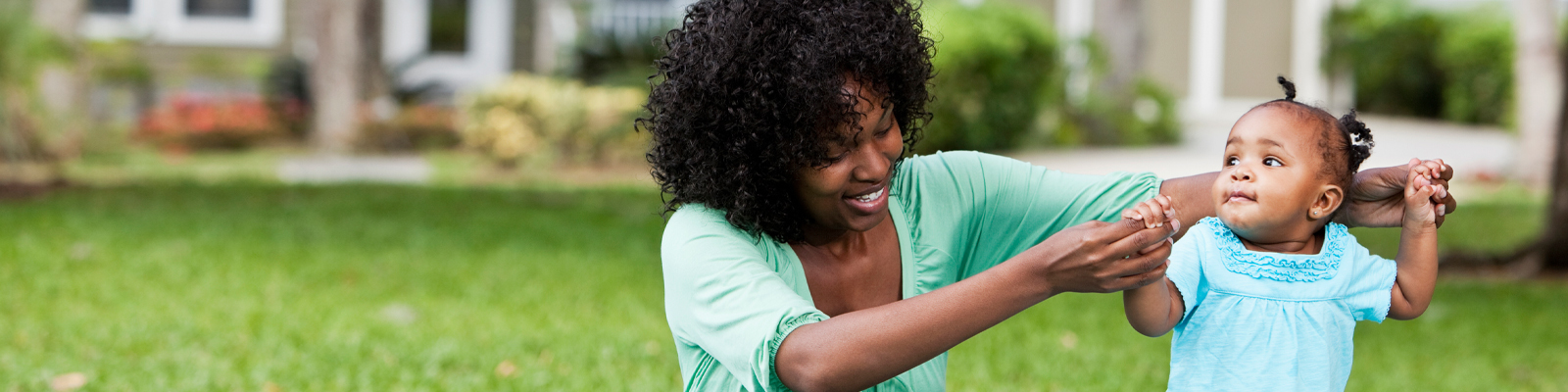 Woman playing with her baby in her yard